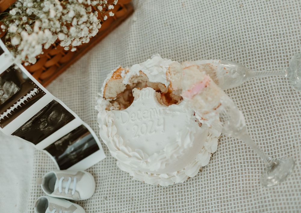 Polaroid photos scattered among white lace doilies and dried flowers on a textured fabric background.