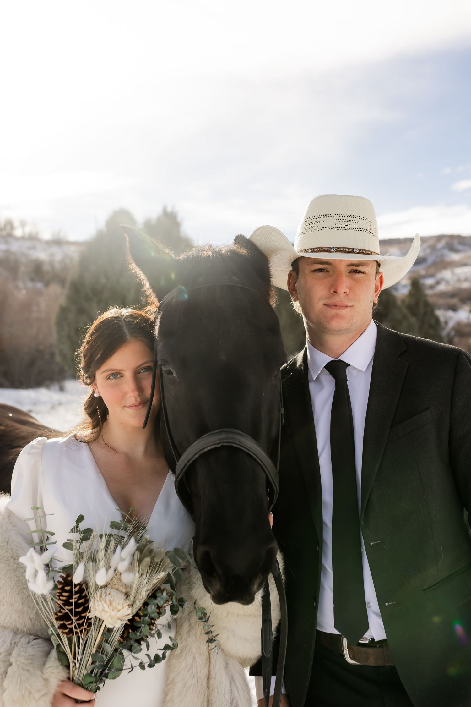 Bride and groom standing with a horse during an intimate winter elopement in Utah