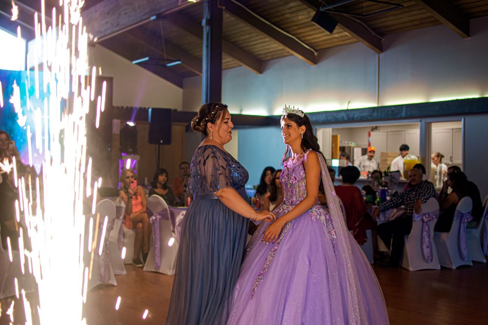 A wedding reception dance floor illuminated with sparklers as guests celebrate during a special moment.