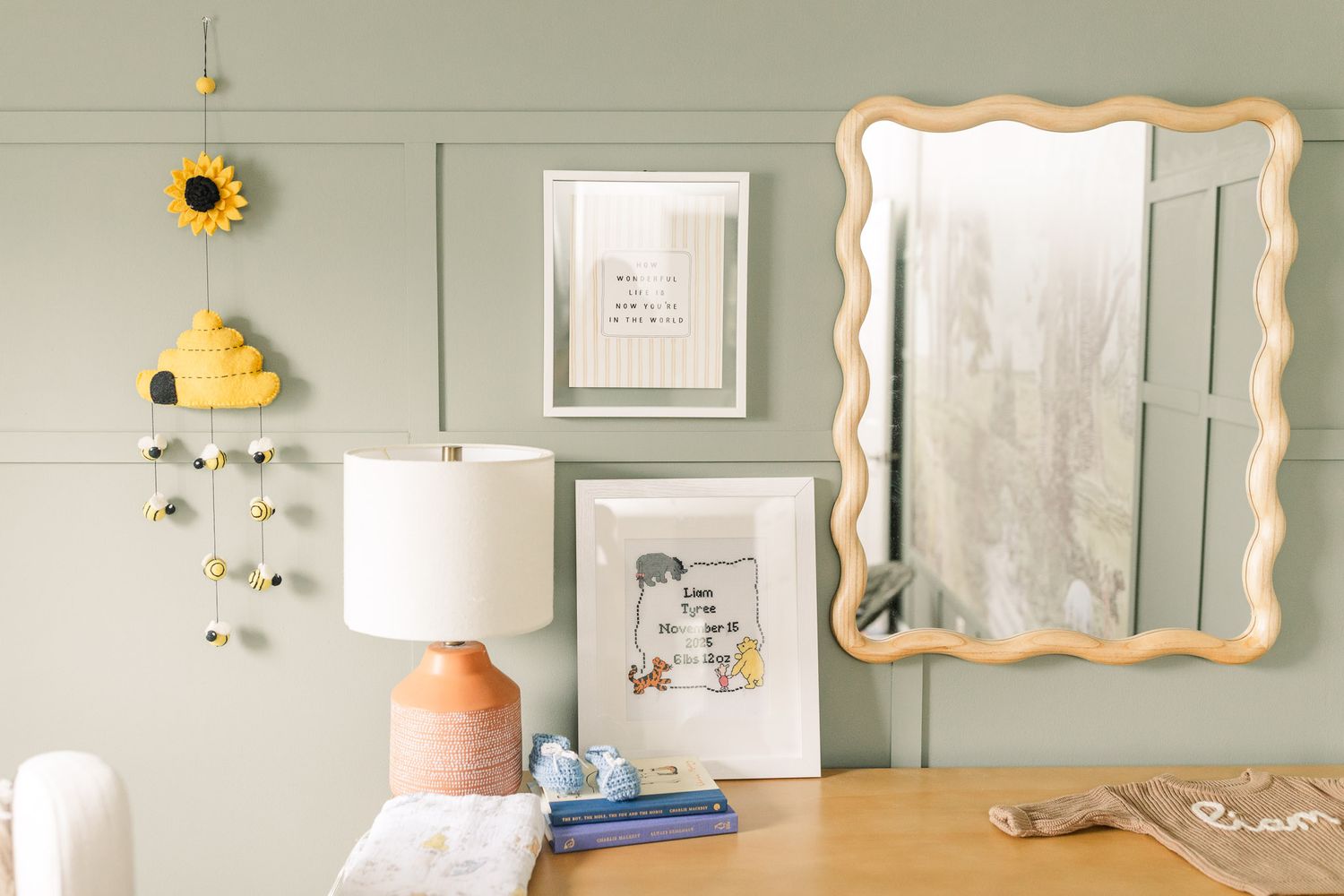 Winnie-the-pooh themed nursery decor with mirror and lamp on dresser