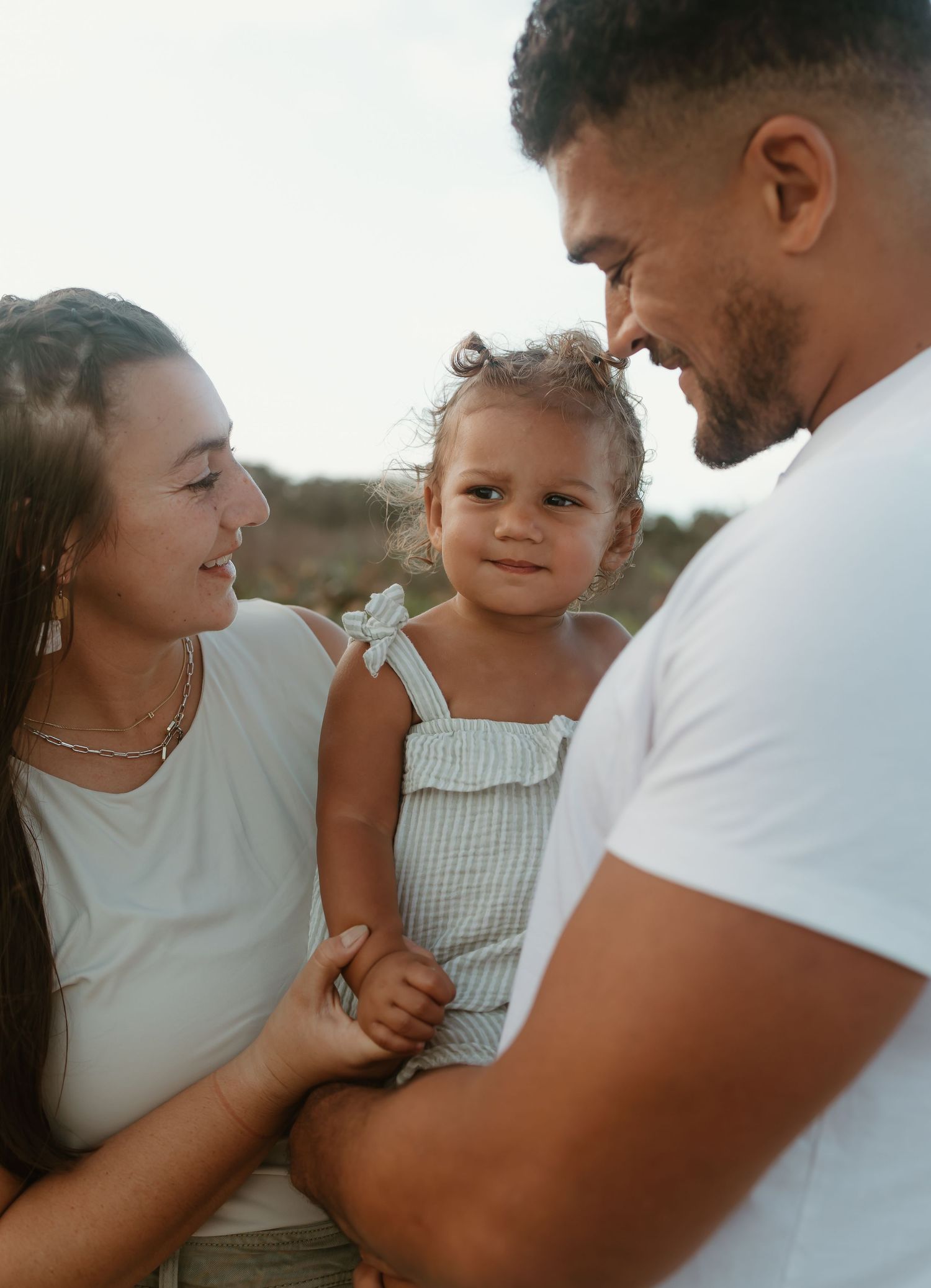 Candid family moment captured outdoors in natural lighting.