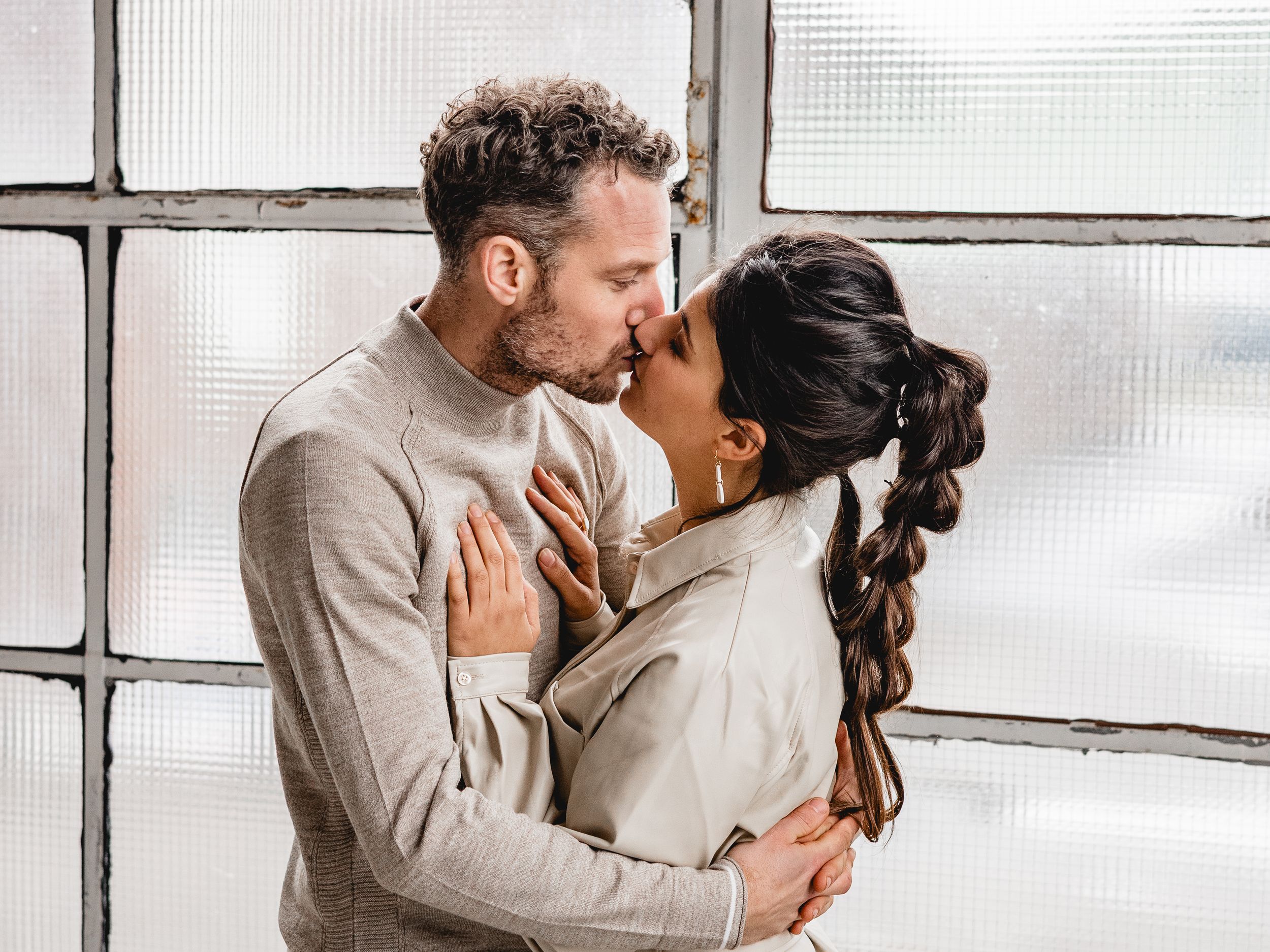 Intimate indoor portrait session with soft window lighting and neutral tones.