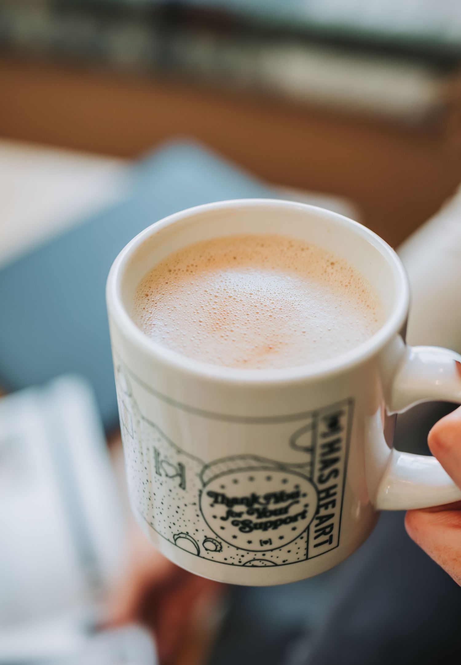 A sequence of images showing a white coffee cup with decorative illustrations being filled with creamy latte art.