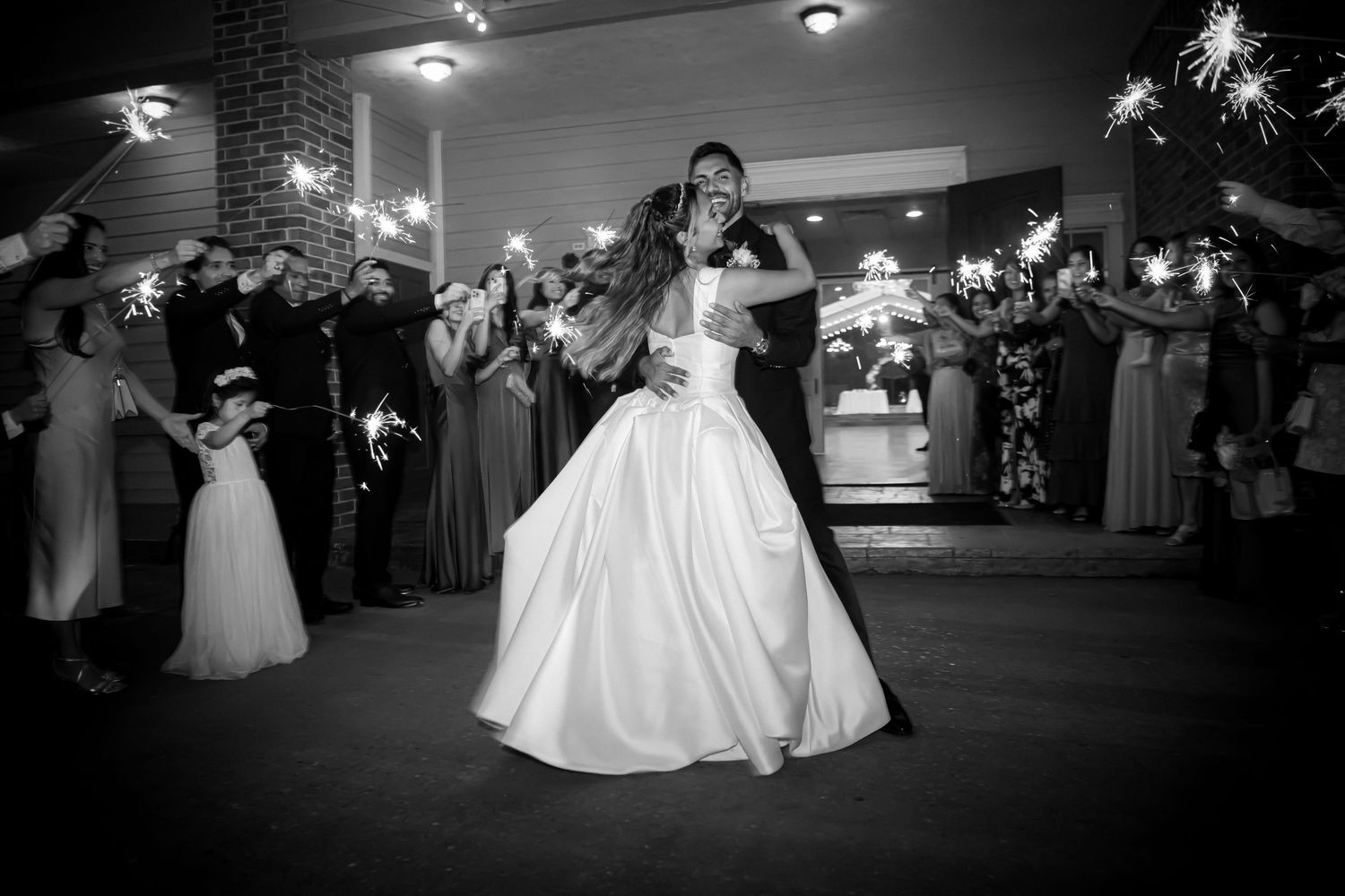 Wedding reception dance in a dimly lit indoor venue with elegant decor.