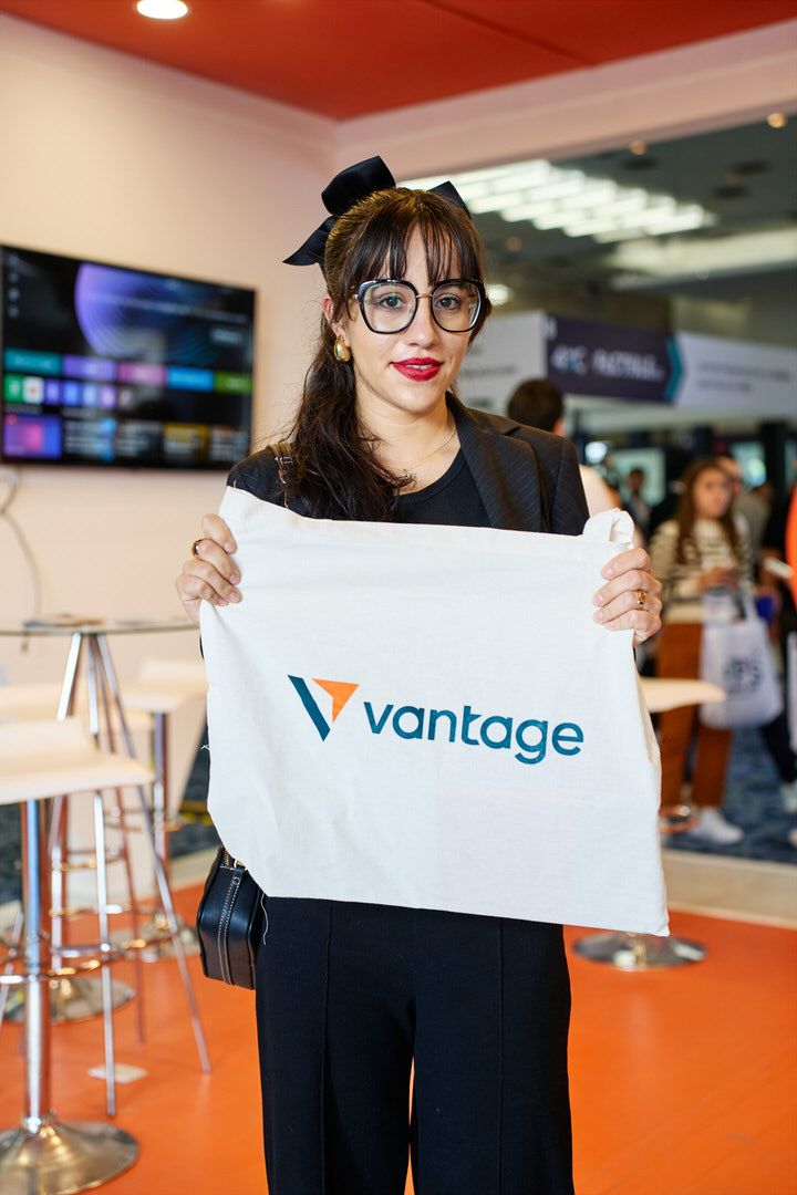 Detalle de branding corporativo y pantallas interactivas en stand de feria financiera.