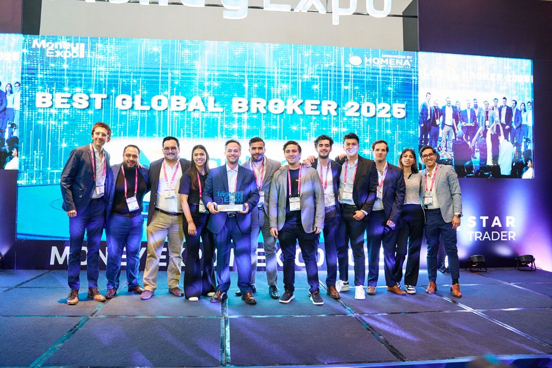 Directivos de Vantage Markets recibiendo premio a la excelencia en el escenario principal.
