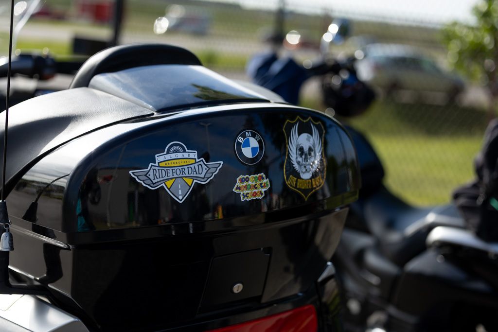 Close-up detail shots of a black BMW motorcycle showing various angles of its sleek design and chrome accents.