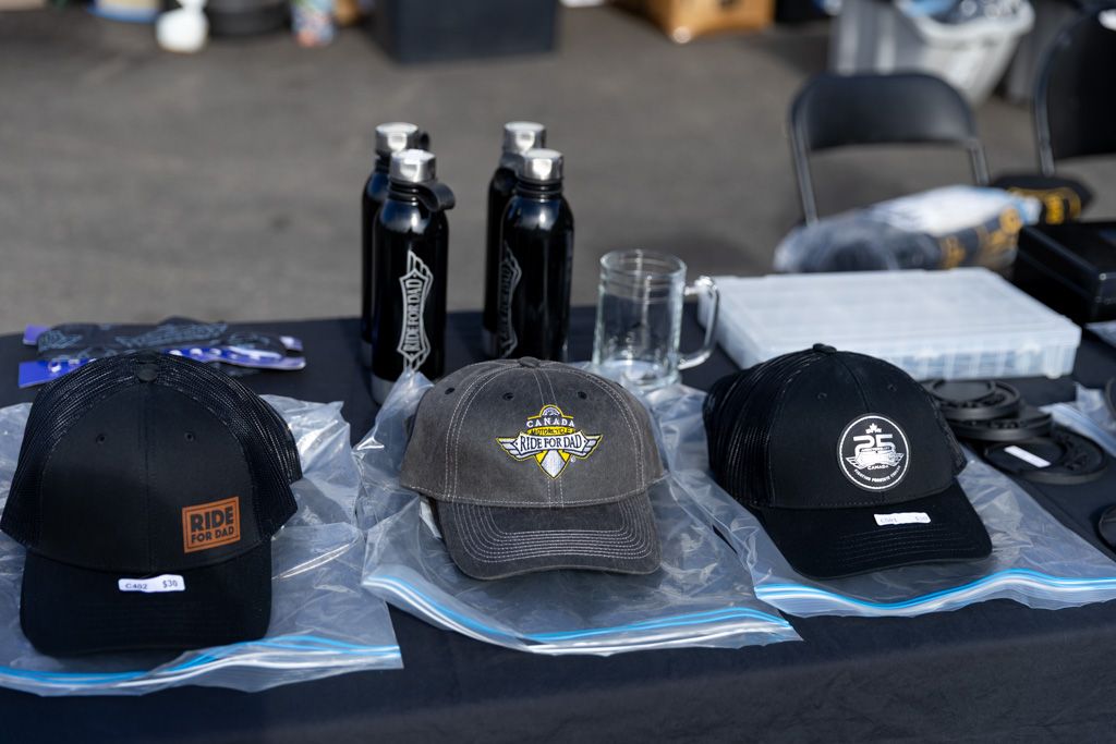 A display of black and gray baseball caps and water bottles arranged on a blue tablecloth.