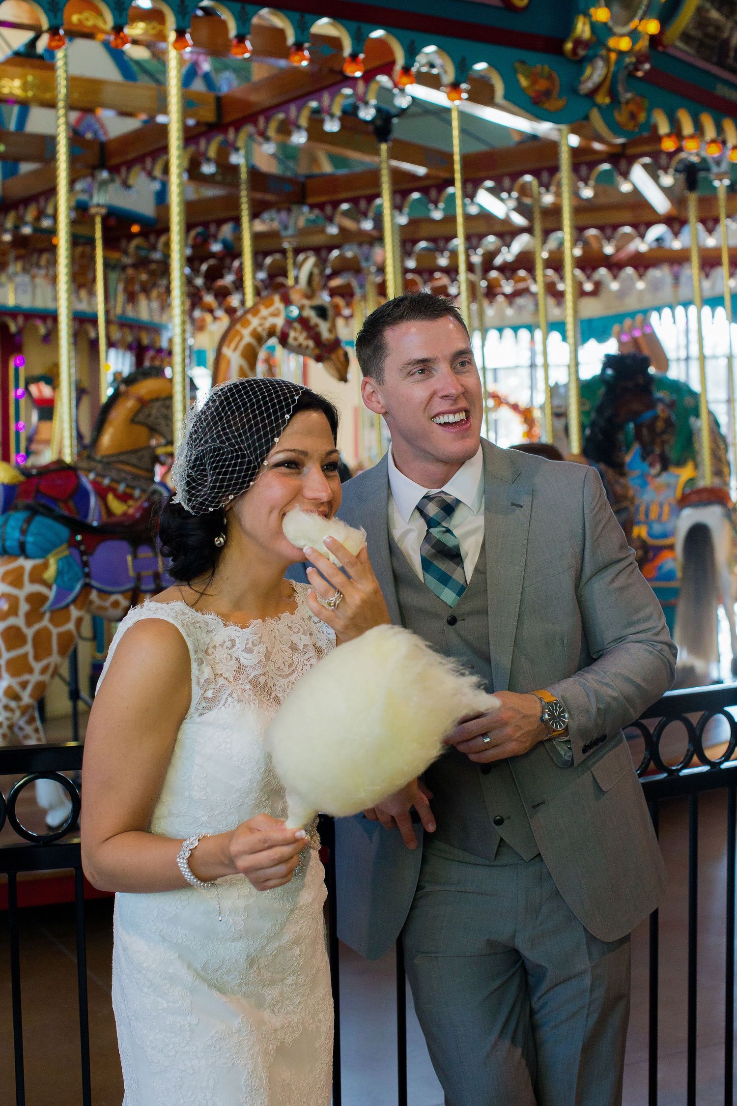 Couple shares a joyful moment on a colorful carousel ride during their wedding celebration.