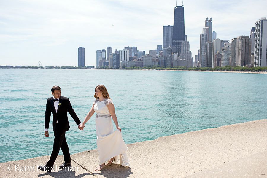 Wedding couple poses along Chicago's North Avenue Beach with the iconic skyline in the background.