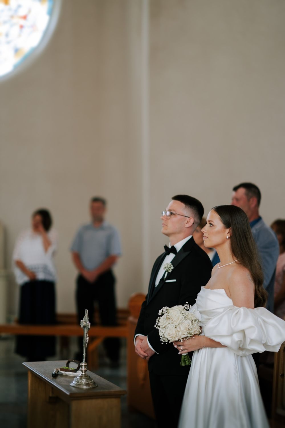 A solemn moment during a church wedding ceremony with the couple standing at the altar.
