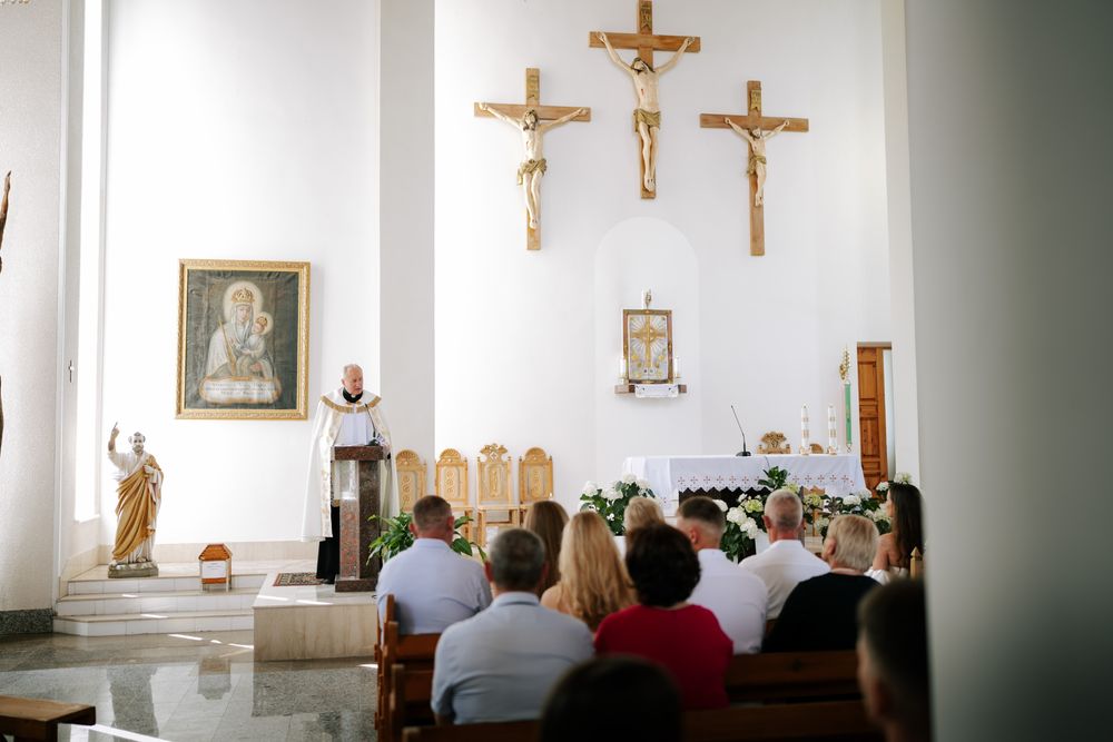 Church interior with crucifix and religious icons during a wedding ceremony.