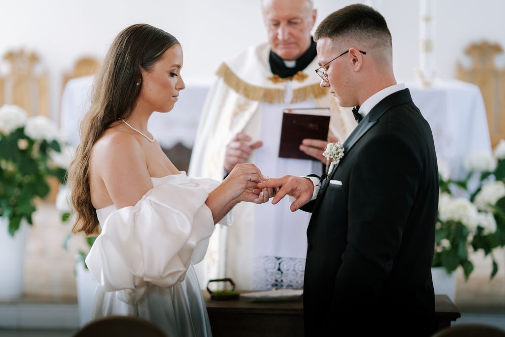 Intimate wedding ceremony moment captured in white church setting.