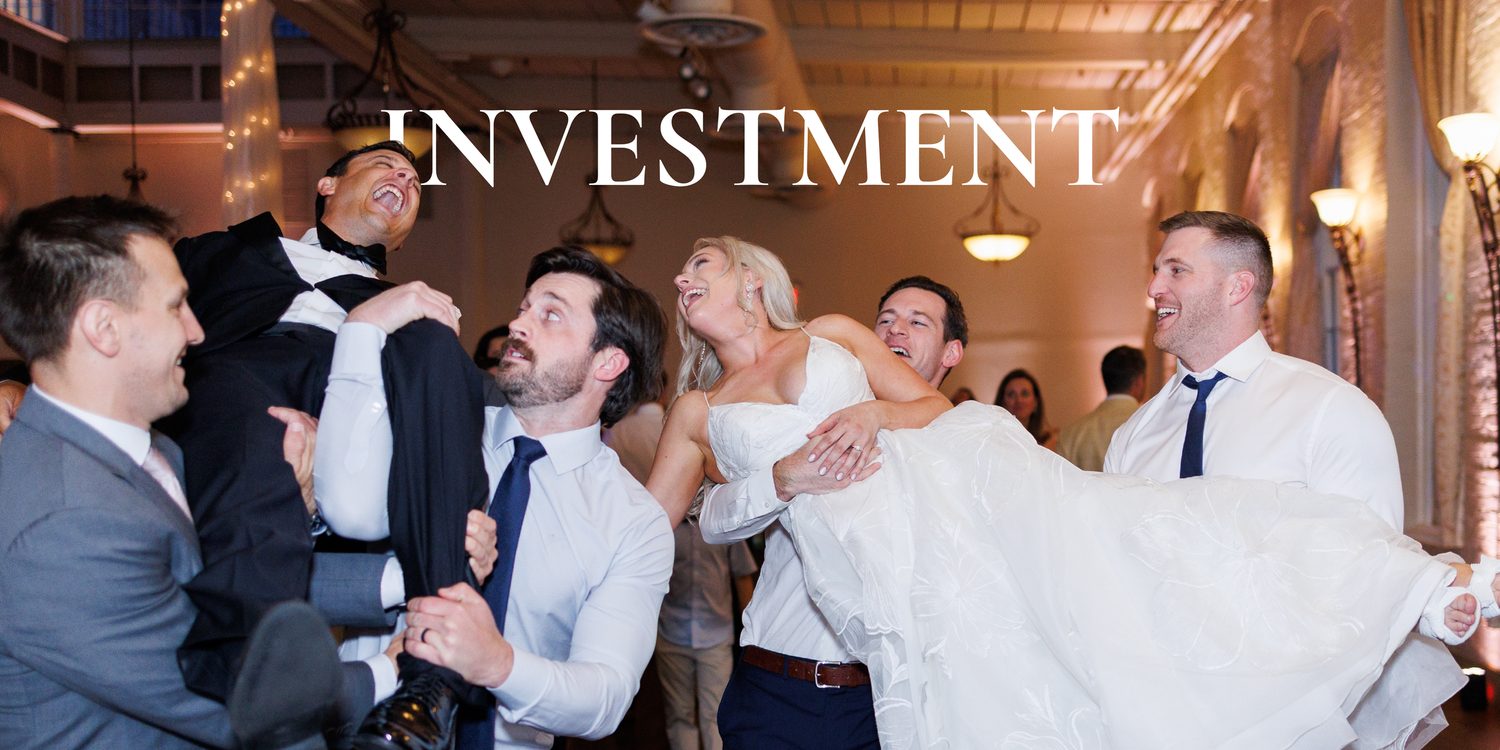 Wedding guests dancing and celebrating together on a dimly lit dance floor at an elegant reception venue.