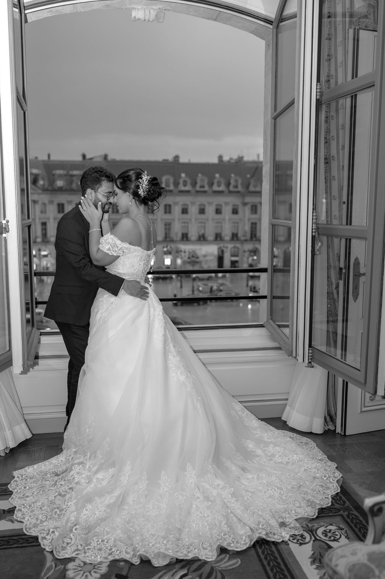 Élégante robe de mariée blanche avec des détails en dentelle complexes et un long train exposé dans une pièce ornée avec des fenêtres.