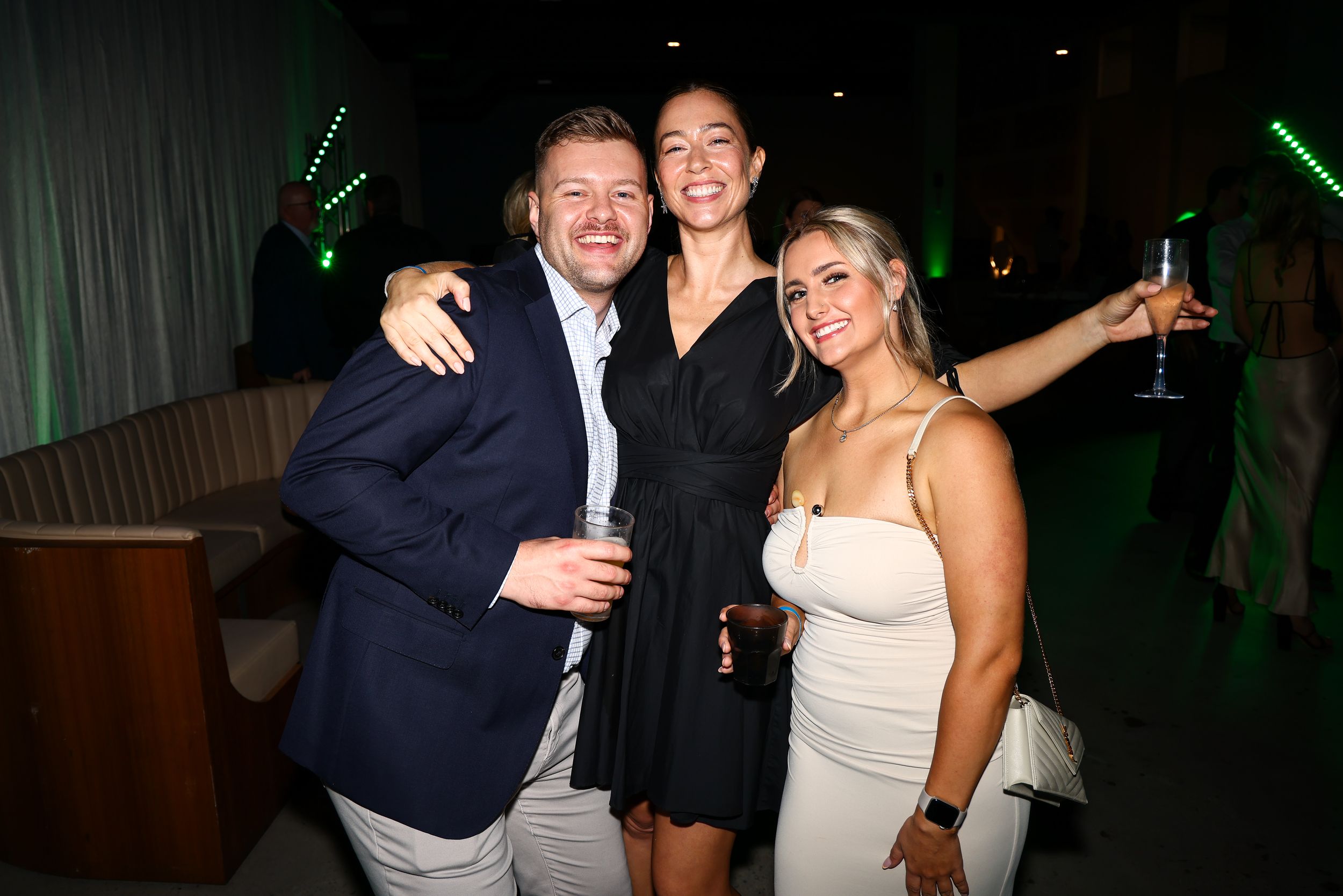 Evening celebration event with atmospheric green lighting and party atmosphere.