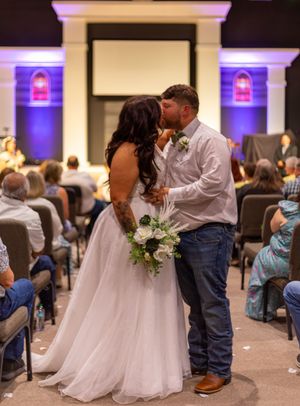 Romantic wedding ceremony kiss in a church venue with guests looking on. Dallas Fort Worth Wedding. North Texas Wedding. Bride and groom