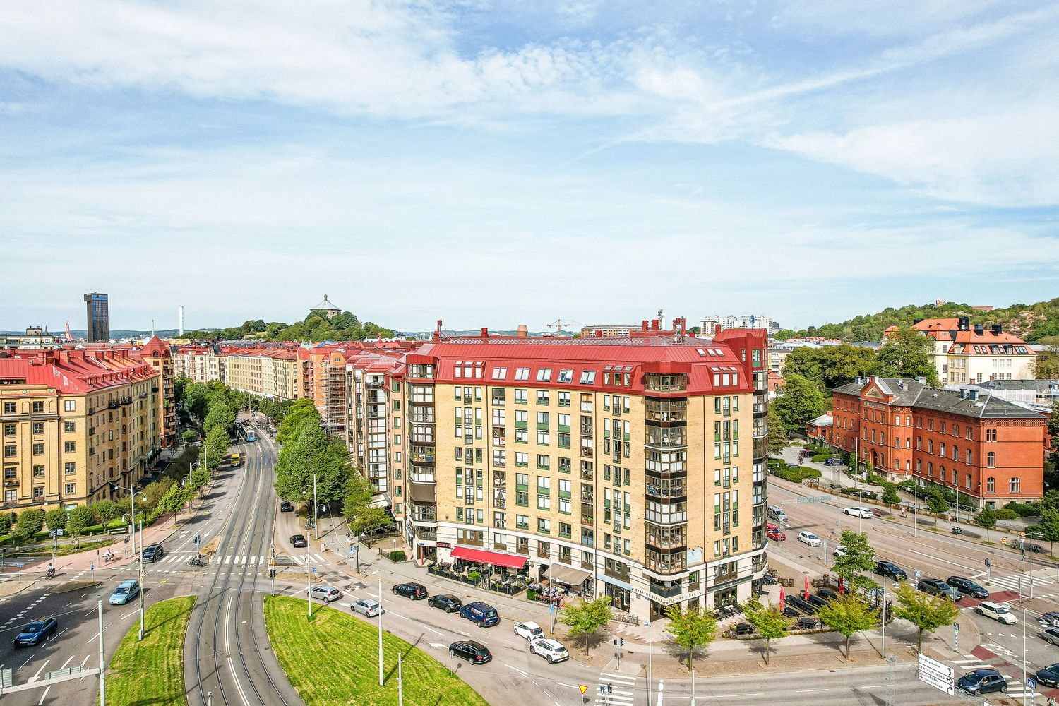 Aerial view of apartment buildings with red roofs and parked cars along a city street in Gothenburg, Sweden.