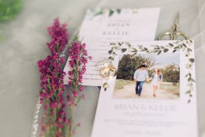 Wedding invitation and photograph displayed with dark pink floral accents.