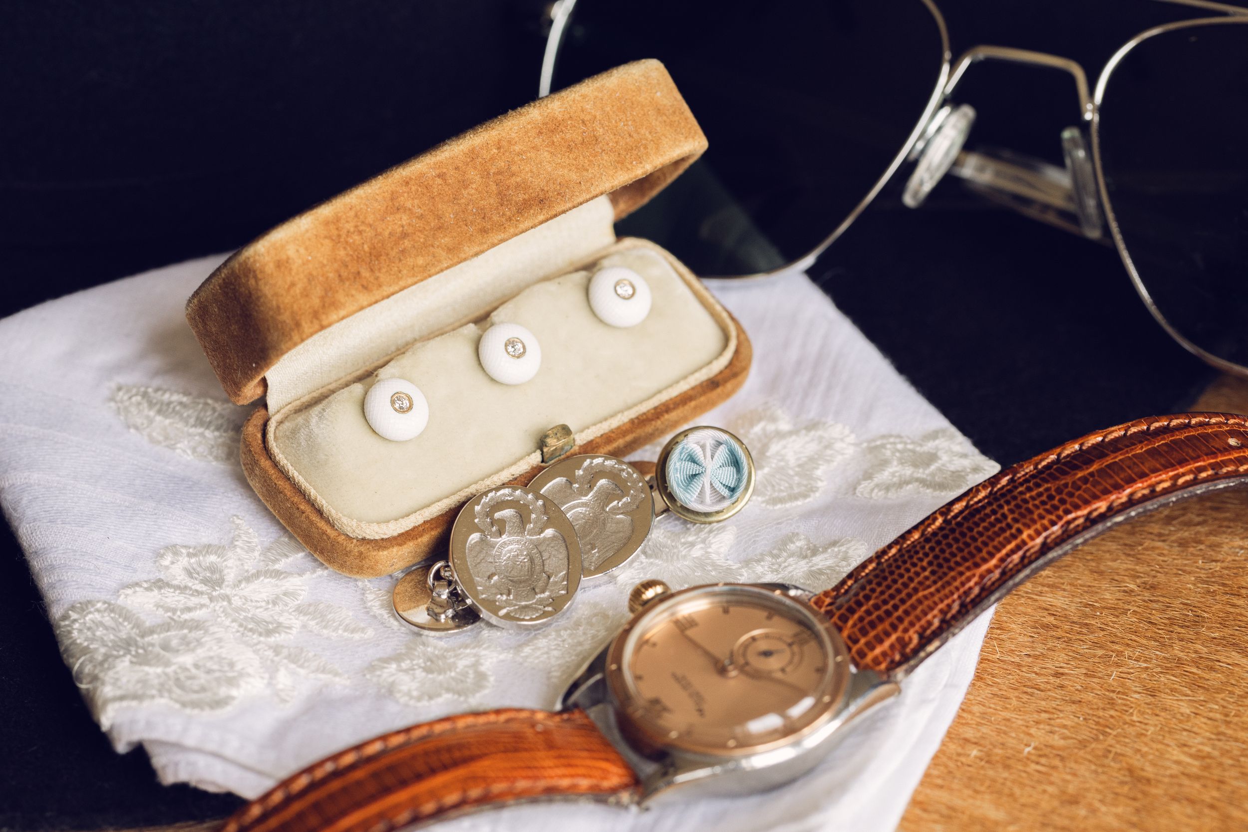 Vintage brown leather watch cases lined up on white lace fabric.