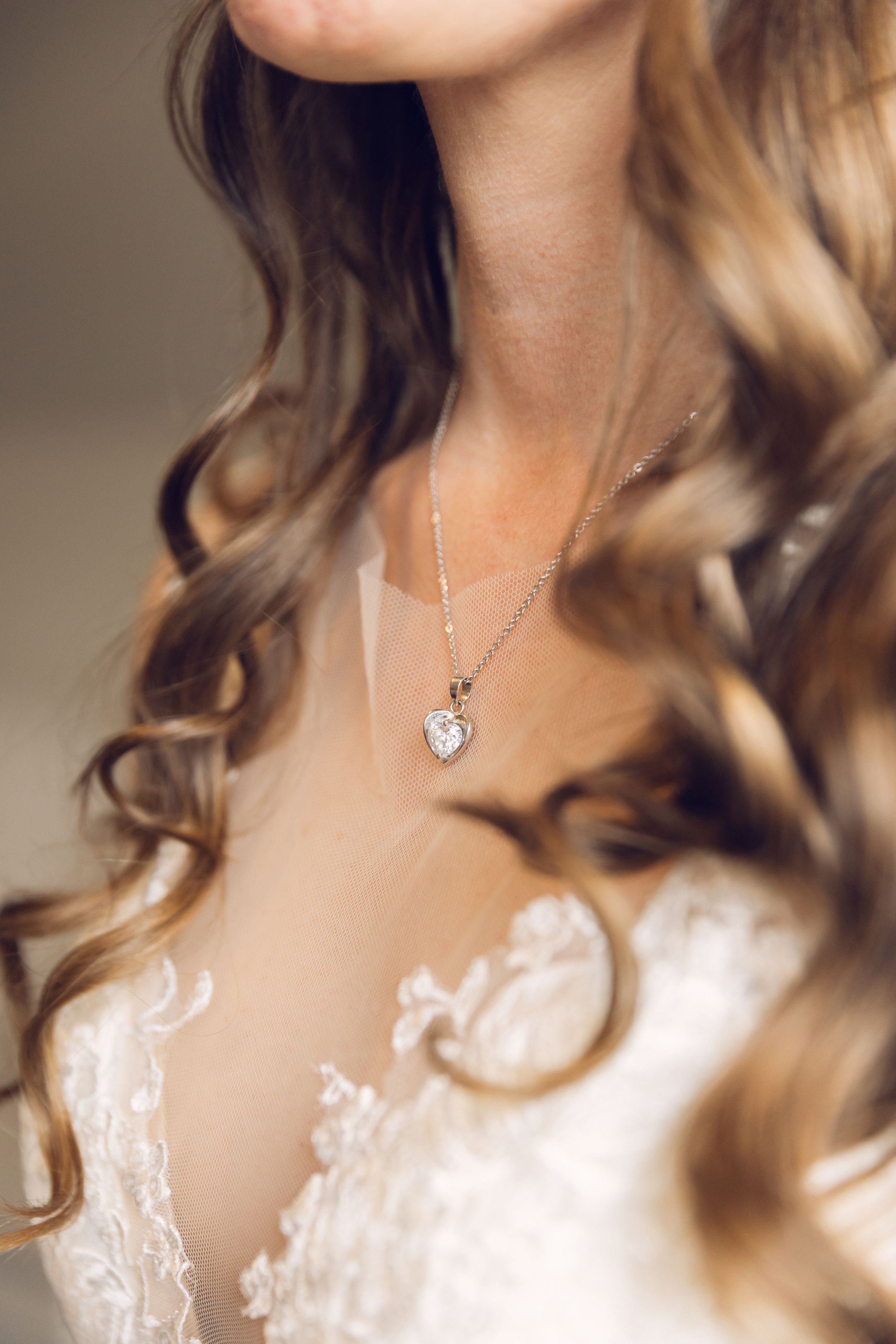 Elegant bridal look featuring wavy blonde hair and delicate necklace.