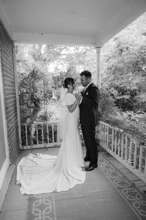 Black and white sequence of wedding portraits on a covered porch showing first look moments and romantic poses.