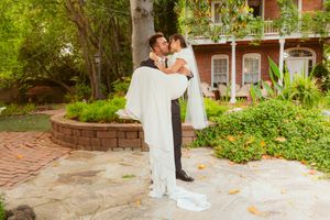 A romantic moment in a garden wedding venue with brick pathways and beautiful landscaping.