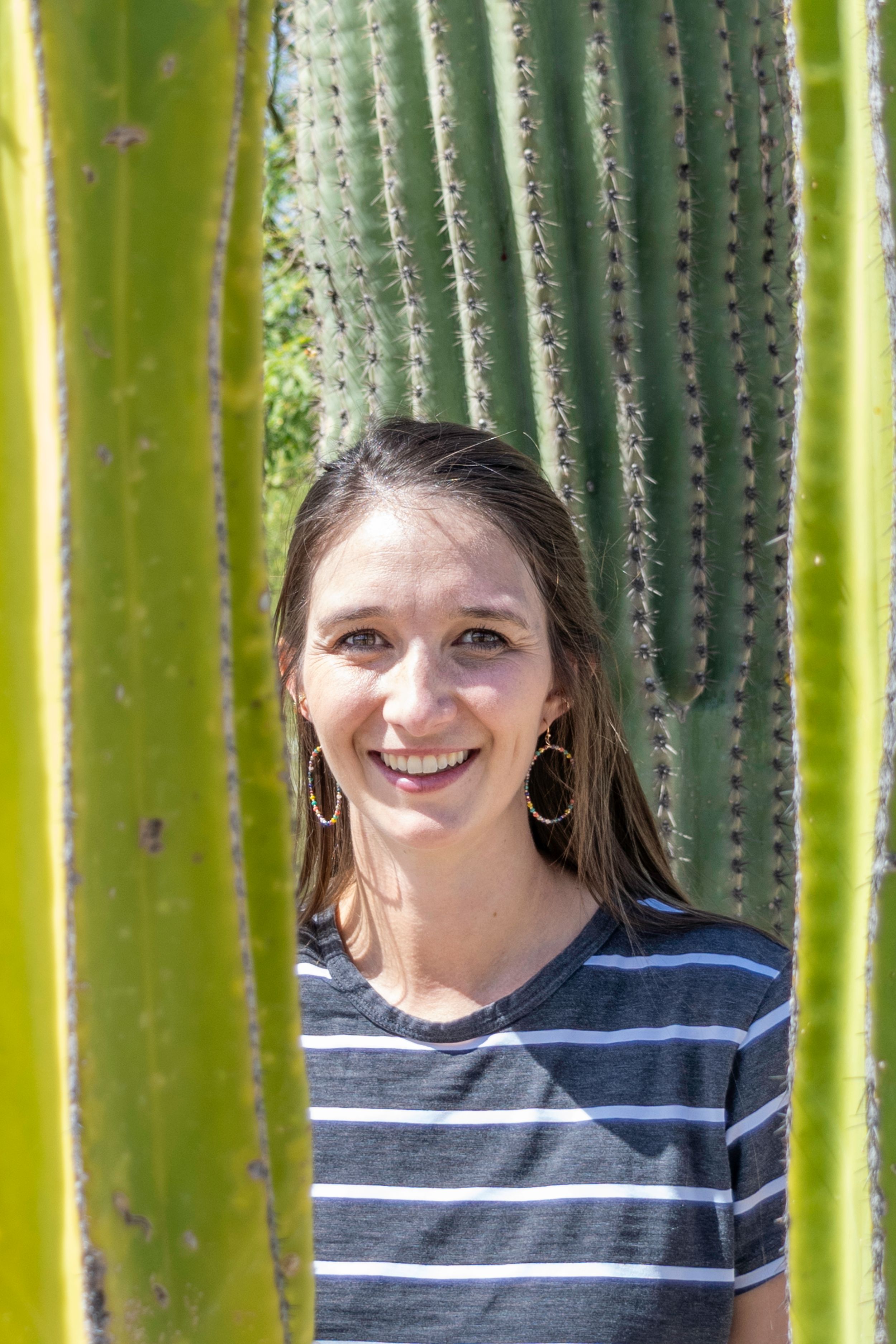 Kasey smiles between cactus in East Tucson