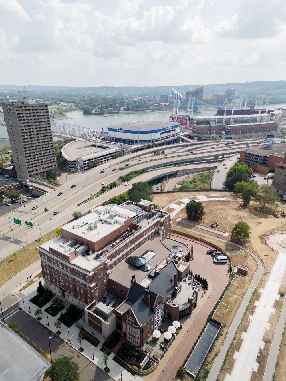 Aerial view of downtown Cincinnati showing Paul Brown Stadium, highways, and historic buildings along the Ohio River.