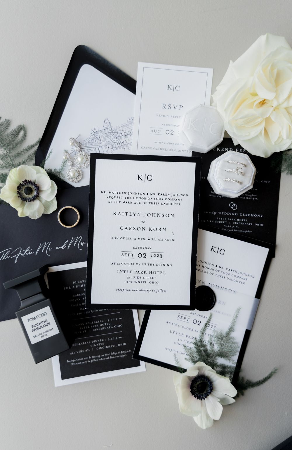 Modern black and white wedding invitation suite with white anemone flowers and minimalist typography.