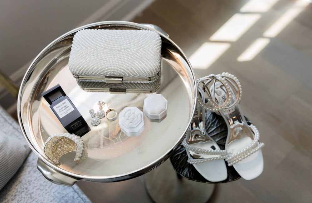 Table setting with wedding favors and place cards elegantly arranged on metallic trays.