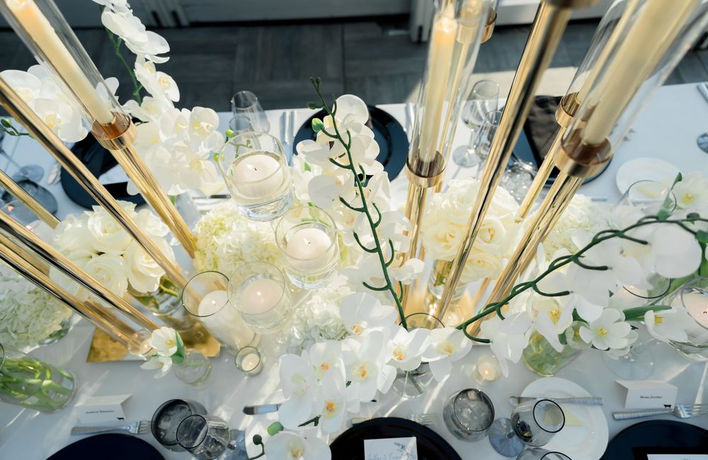Collection of white cherry blossoms arranged with golden sunburst decor elements in a decorative floral display.