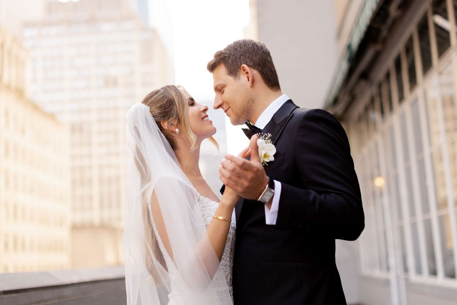 A bride and groom share an intimate dance moment together while celebrating their wedding day outdoors.