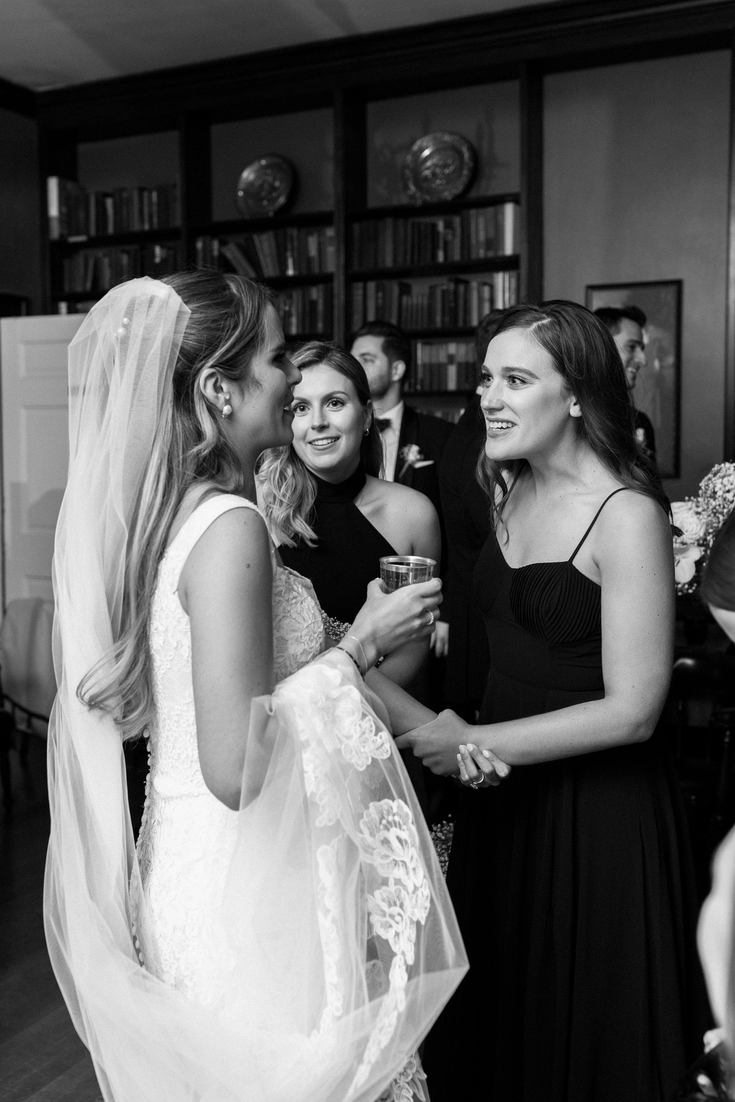 Wedding celebration scene with women in formal attire sharing a joyful moment.