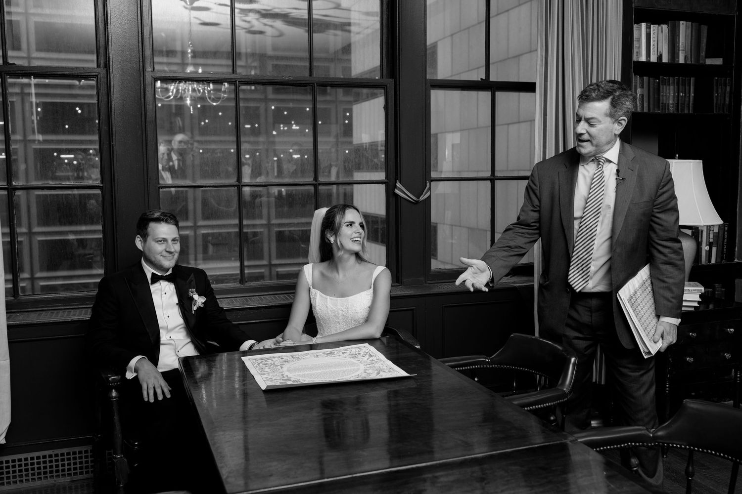 Candid moment captured during wedding reception in library setting.