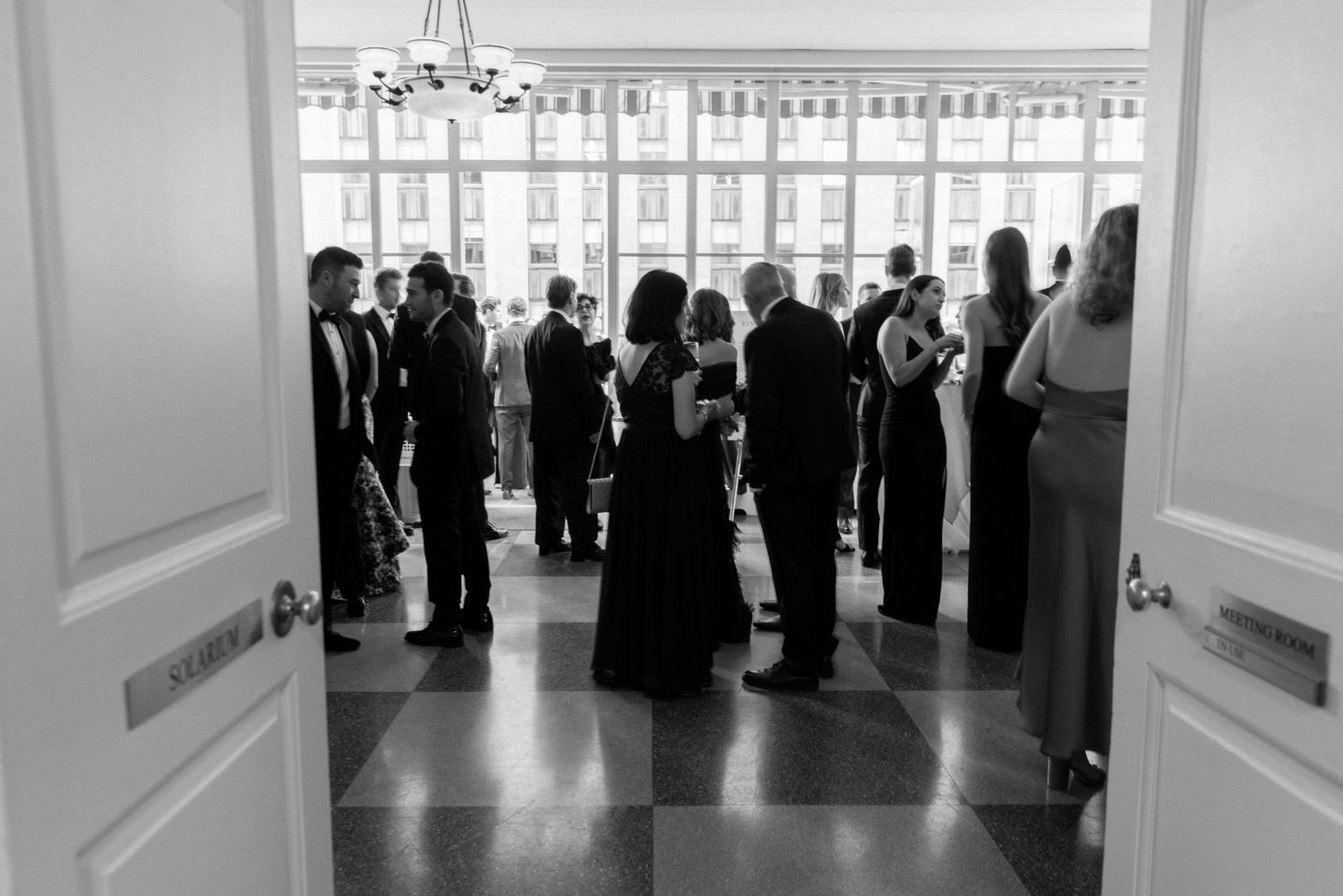 Wedding guests mingling in formal attire at elegant reception venue.