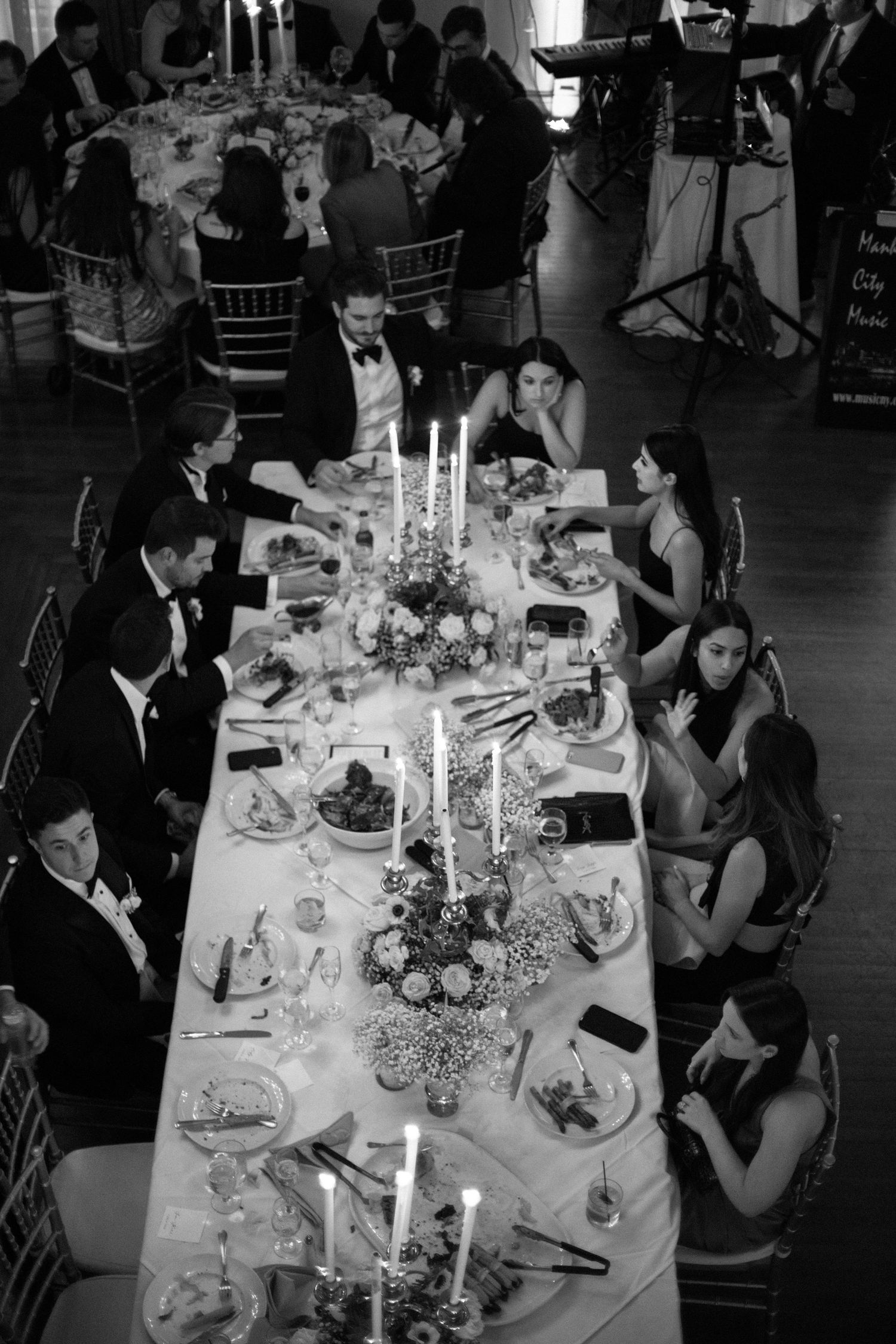 Elegant wedding reception table set with candles and floral centerpieces at a formal dinner.