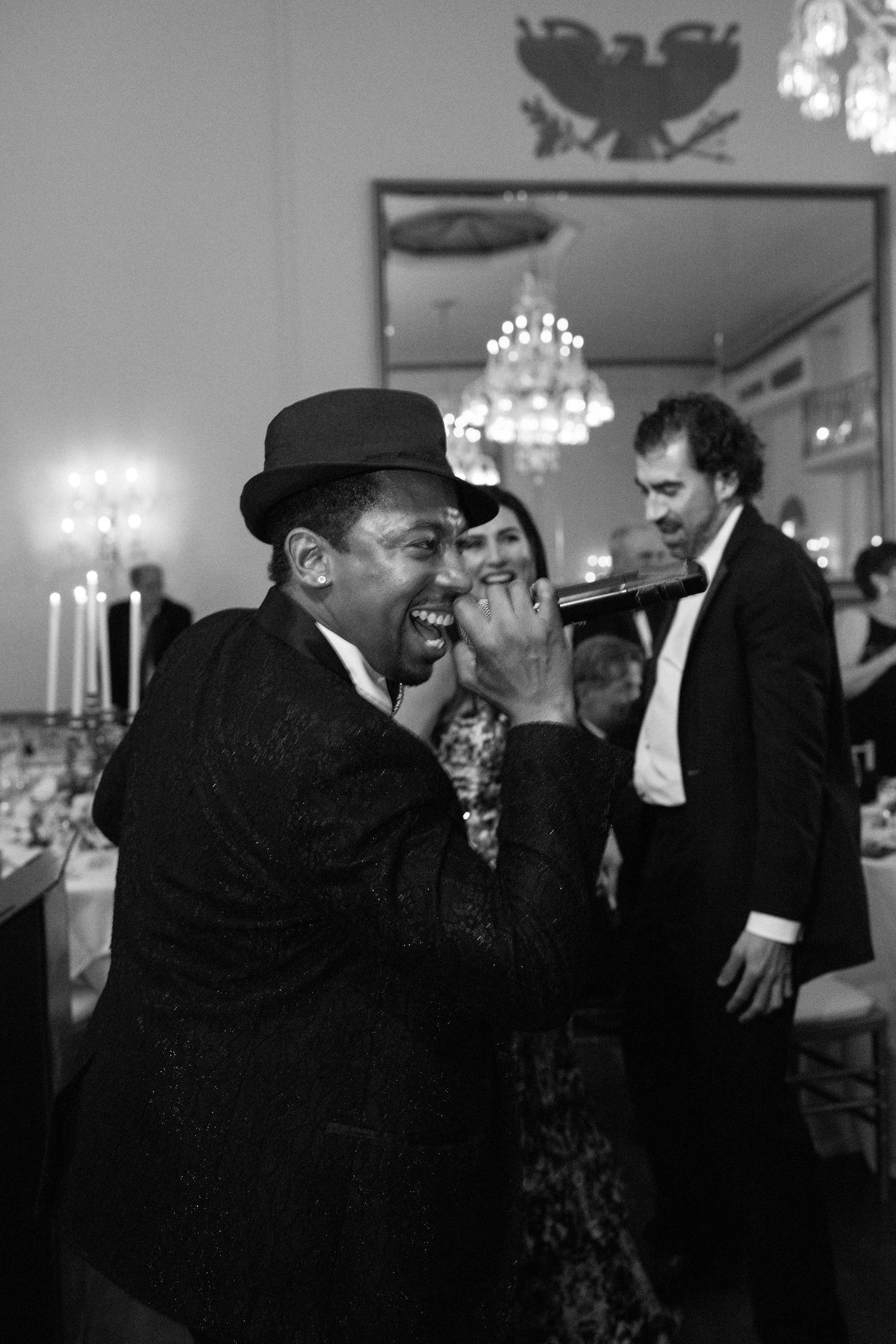 Wedding performer in bowler hat entertains guests during the reception celebration.