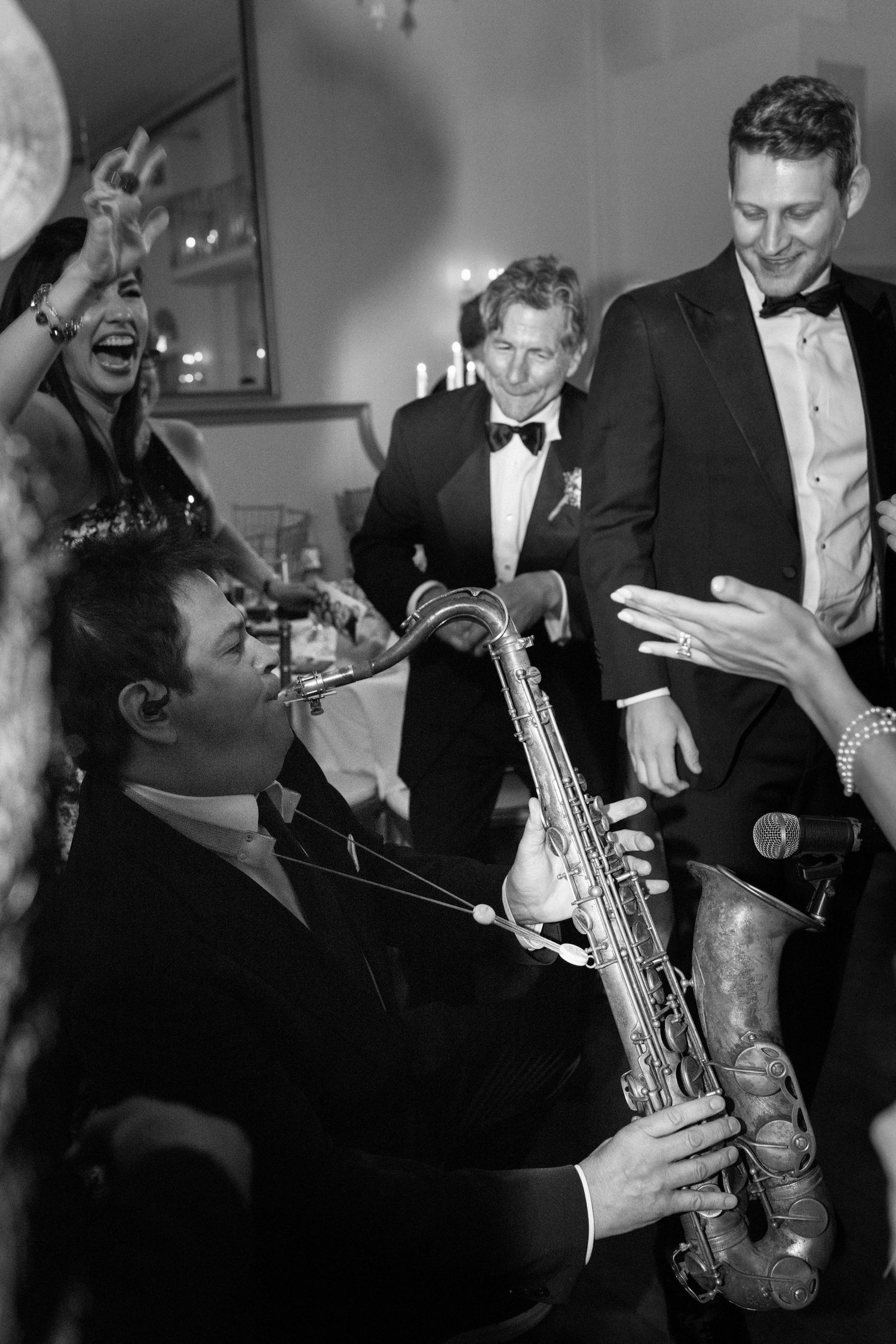 Musicians perform with saxophone and instruments at an elegant black-tie event.