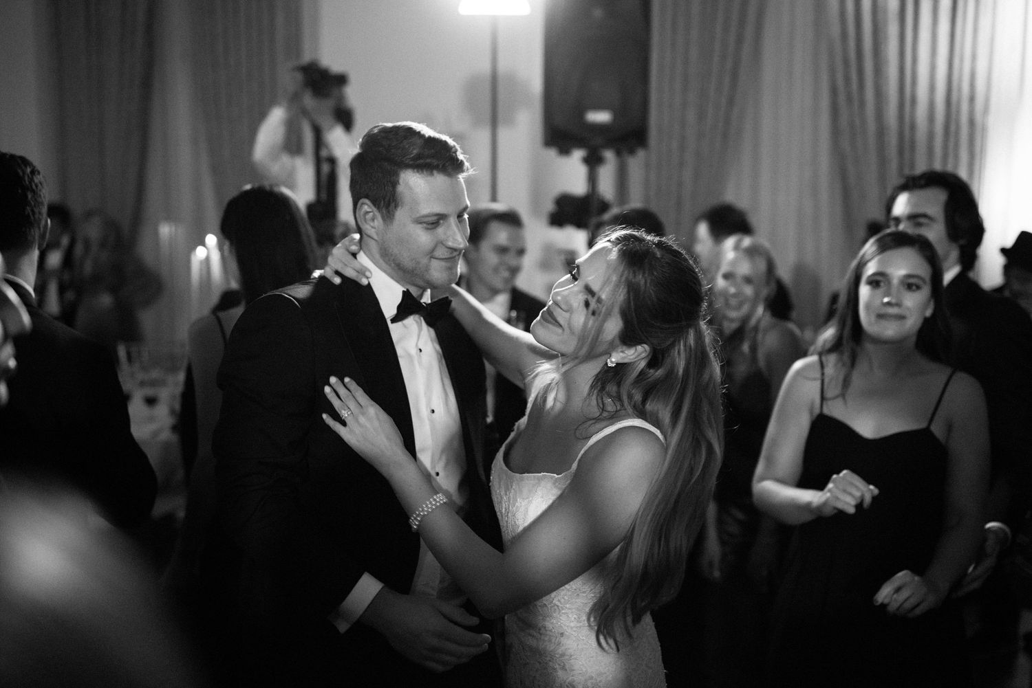 Black and white photo of couple dancing at an elegant wedding reception.