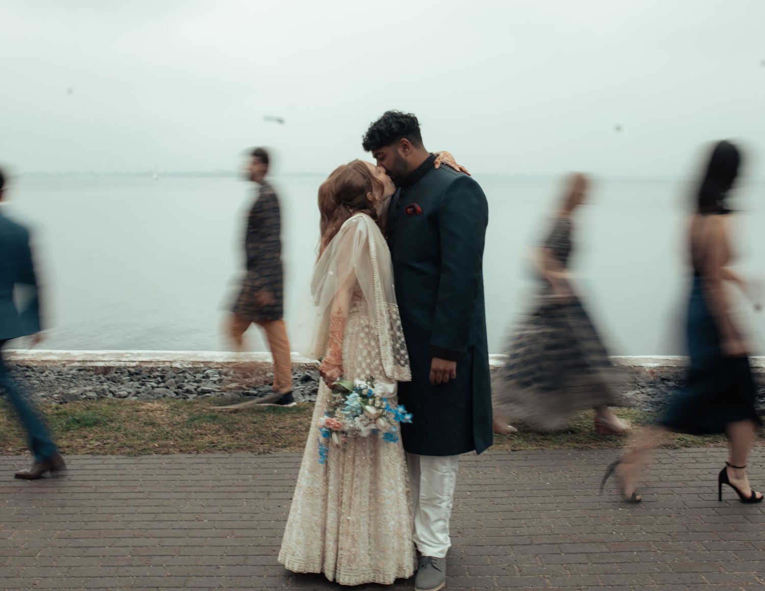 Couple de mariés au ralenti devant le Tett Centre à Kingston, en bord de l’eau, ambiance romantique et intemporelle.