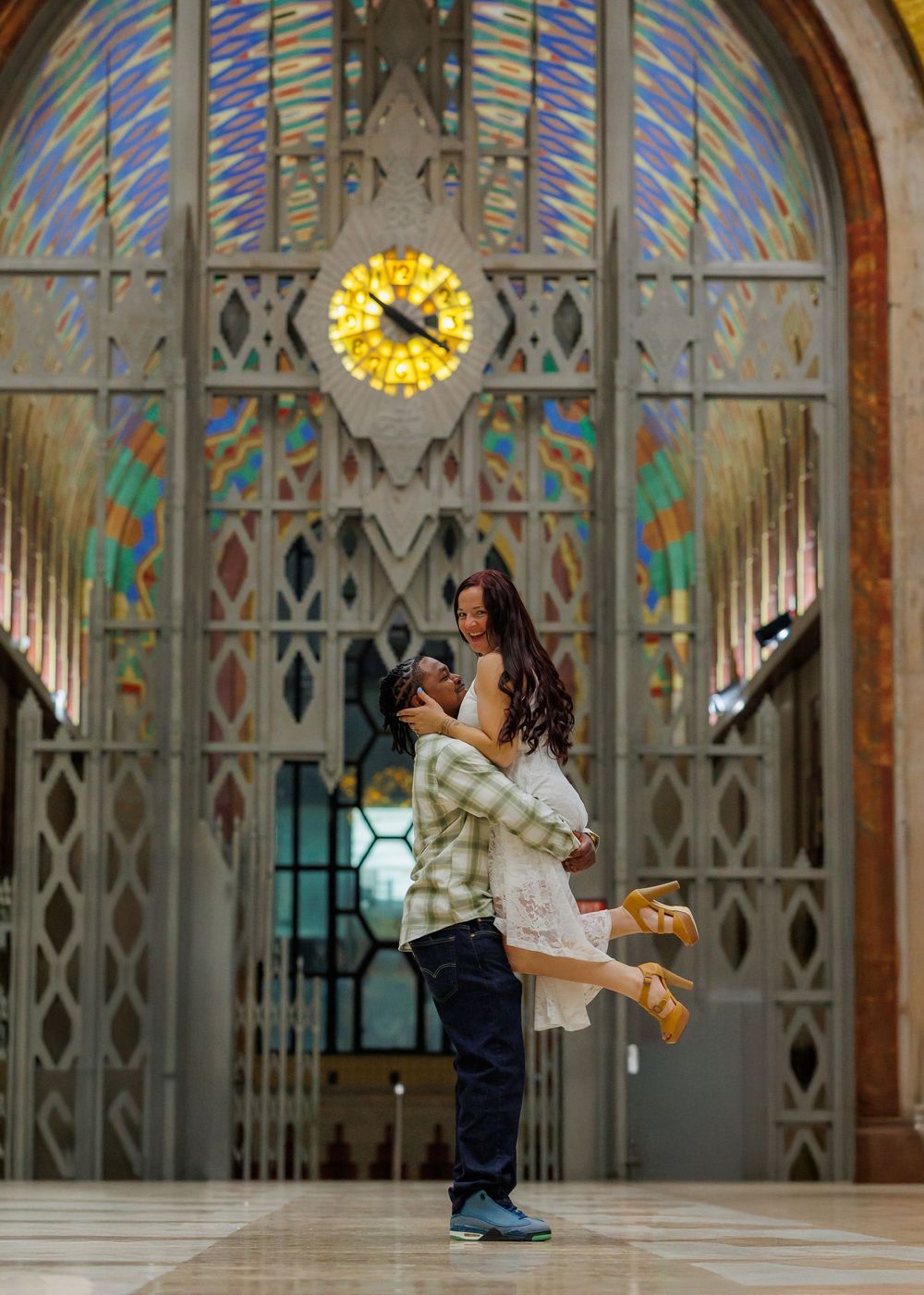 Contemporary dancers perform graceful lifts and poses in sequence against a gothic arched interior with stained glass windows.