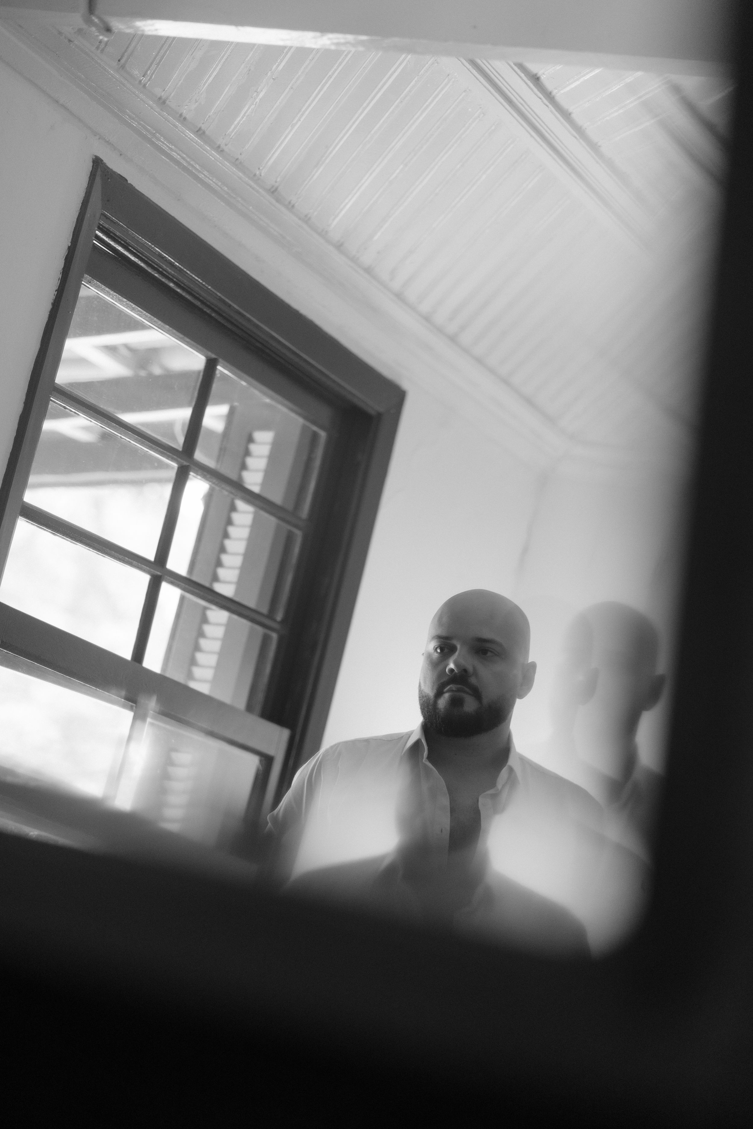 Black and white artistic portrait shots with window lighting and stark shadows.