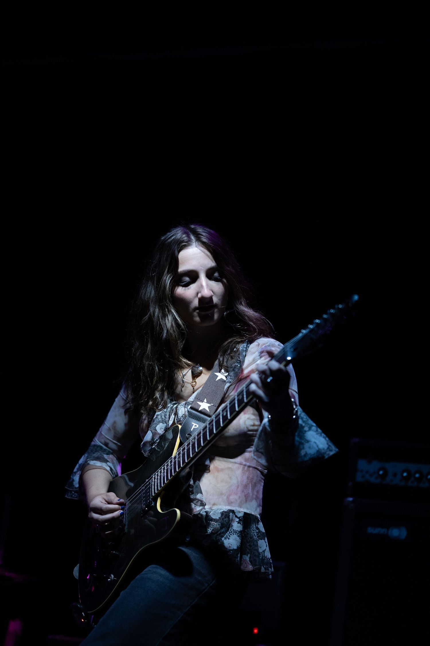A musician from Karass performs at a concert event under a bright spotlight at Burlington Bar in Chicago