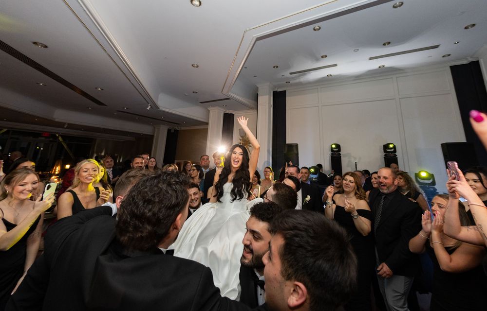 Bride lifted above guests during an energetic wedding celebration at Glen Island Harbour Club in Westchester County.