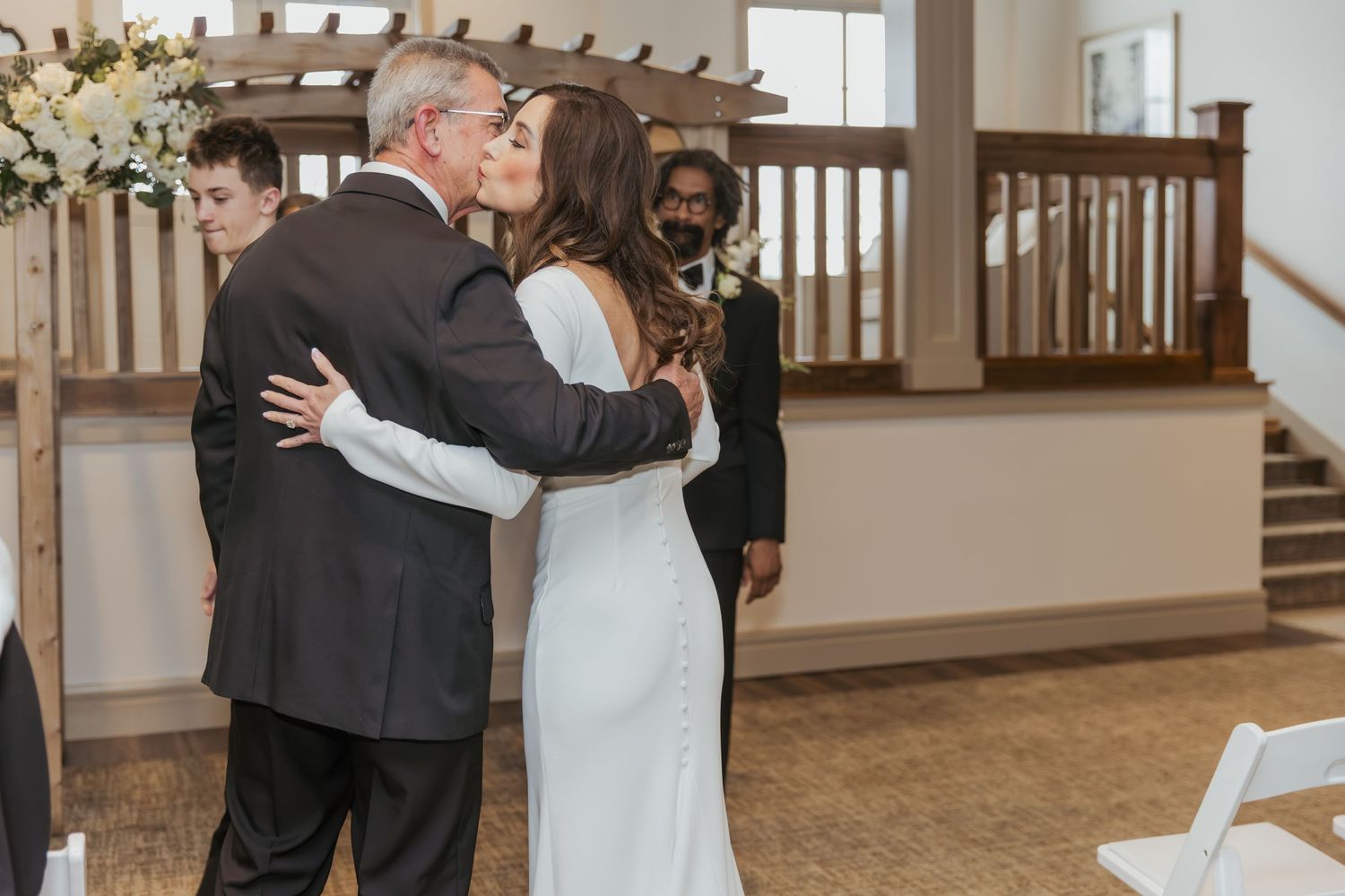 Bride walking down the aisle with her dad and giving him a kiss on the cheek at her wedding in Holliday Farms in Zionsville, Indiana