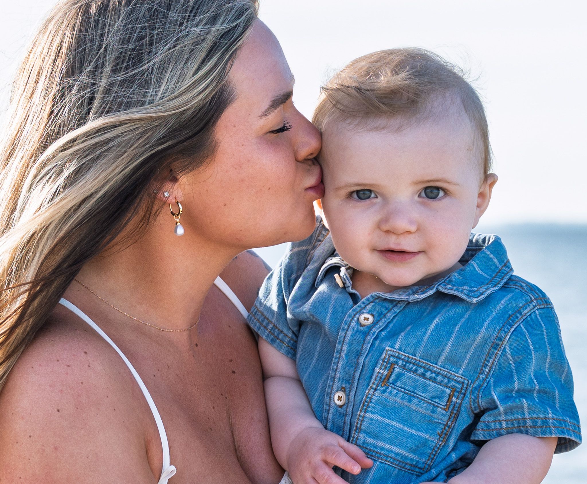 A mom kisses her baby.