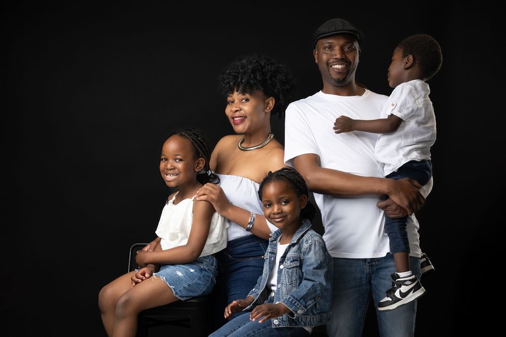 Emotional family portrait with elegant dark background studio lighting.