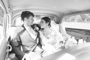 Bride and groom sharing an intimate moment in a vintage car after their wedding ceremony.