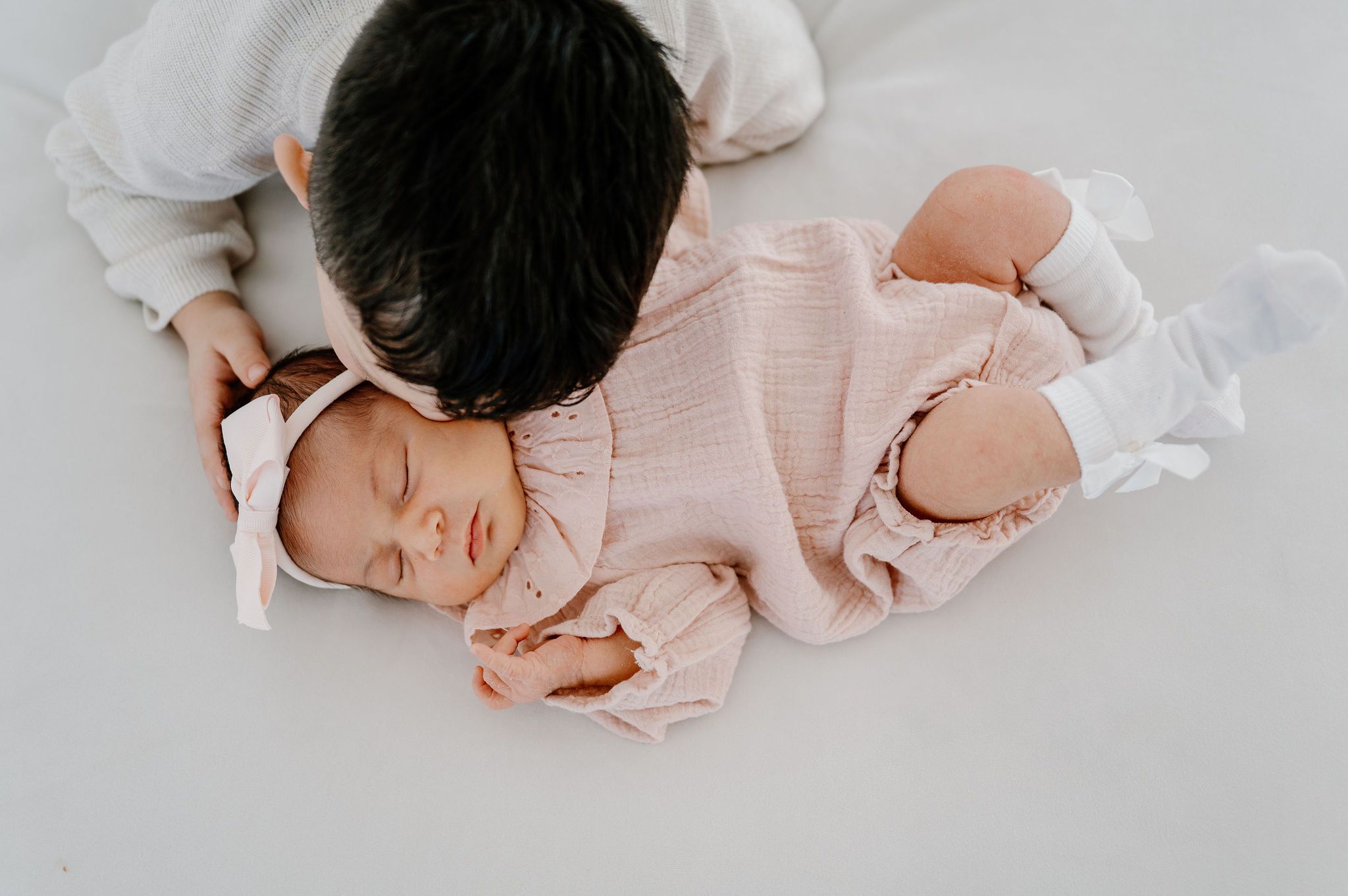 Little brother kisses baby sistes cheek during Studio newborn photos at Casa Blanca, Tri-Cities